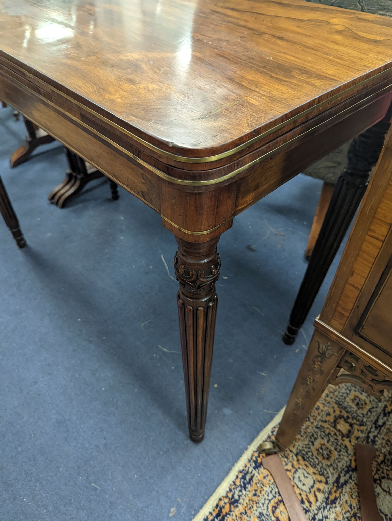 A Regency rosewood brass mounted rectangular folding card table with fluted legs, in the manner of Gillows, width 95cm, depth 47cm, height 75cm